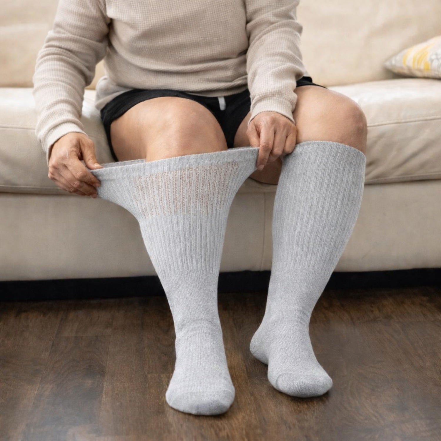 Personne assise portant des chaussettes diabétiques extra-larges grises au quotidien